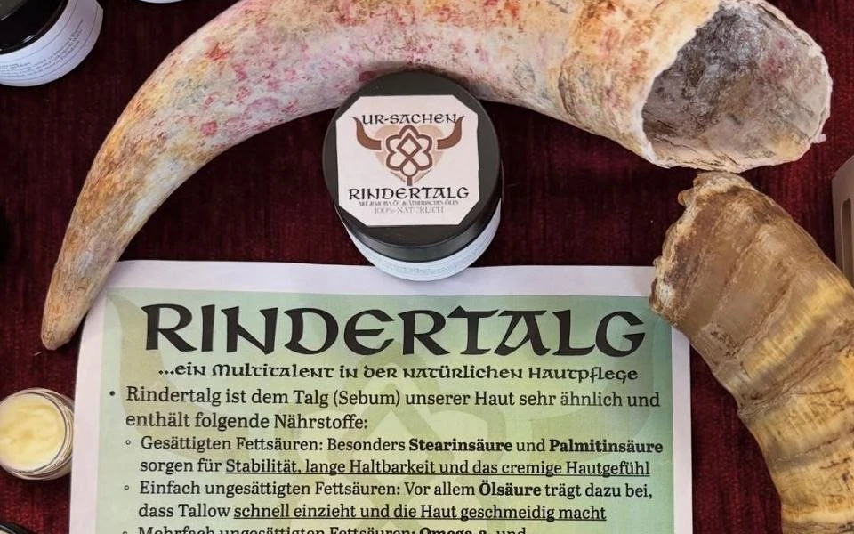 Tiegel Rindertalg Pflegesalbe vor einem Rinderhorn auf dem Infoblatt der Marke